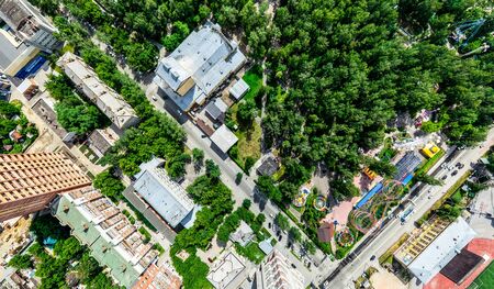 Aerial city view with crossroads and roads, houses, buildings, parks and parking lots. Sunny summer panoramic imageの写真素材
