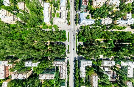 Aerial city view with crossroads and roads, houses, buildings, parks and parking lots. Sunny summer panoramic imageの写真素材