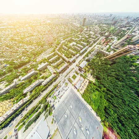 Aerial city view with crossroads and roads, houses, buildings, parks and parking lots, bridges....