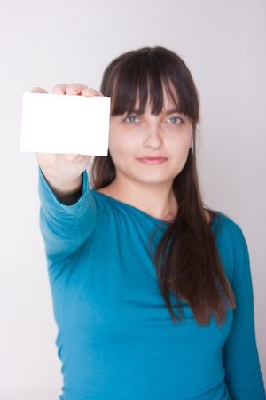 Attractive caucasion girl with business or gift card. Selective focus. Space for text available.の写真素材