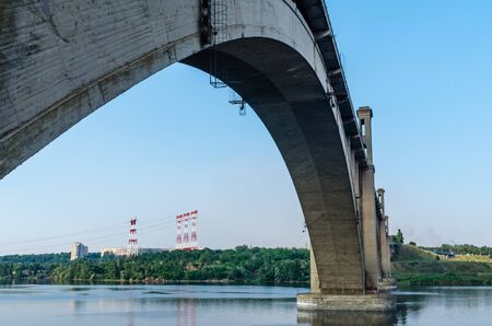 road and rail split-level bridge over the river on a background of blue sky in the city