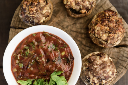 baked mushrooms with meat and sauce on a woodの写真素材