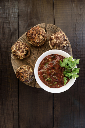 baked mushrooms with meat and sauce on a woodの写真素材