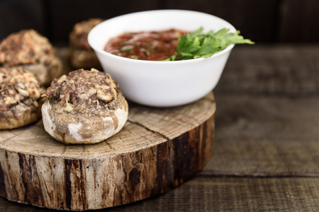 baked mushrooms with meat and sauce on a woodの写真素材