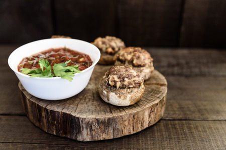baked mushrooms with meat and sauce on a woodの写真素材
