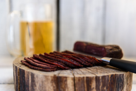 pastrami beer in a glass knife on a wooden tableの写真素材