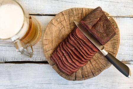 pastrami beer in a glass knife on a wooden tableの写真素材