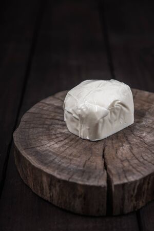 white mozzarella cheese on a wooden end of a treeの写真素材