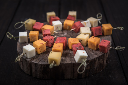 many kinds of cheeses on wooden end of a treeの写真素材