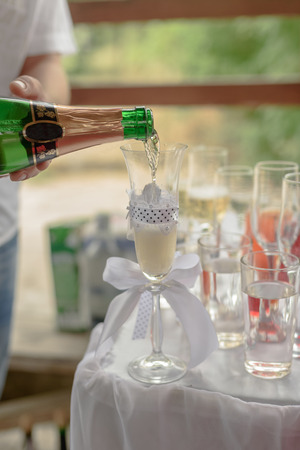 the waiter pours champagne into glassesの写真素材