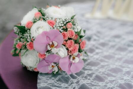 wedding bouquet of roses and orchids is on the tableの写真素材