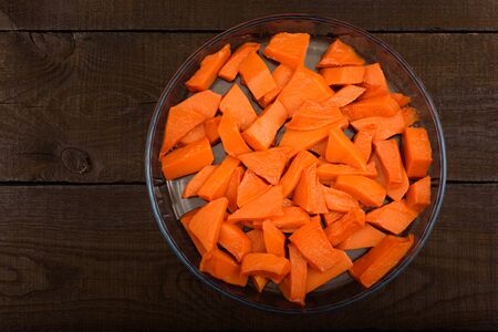 sweet baked pumpkin chopped lomikami in glass dish on wooden backgroundの写真素材