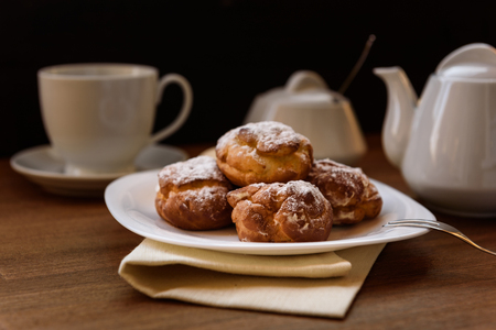 eclairs with custard cream with tea and teapotの写真素材
