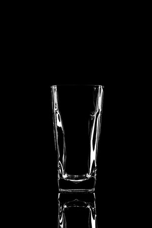 transparent glass for brandy or cognac on black background with reflectionの写真素材