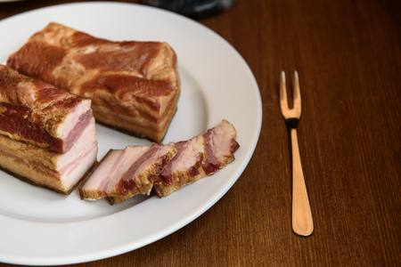 smoked pork ribs on white plate on wooden backgroundの写真素材