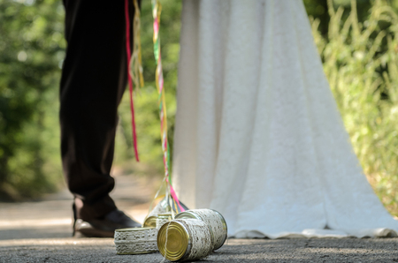 tin cans tied with ribbons, the bride and groom are holding the ribbonの写真素材