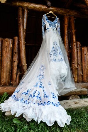 bridesmaid dress in the style of Gzhel hanging on a wooden beam in the input aperture of the houseの写真素材