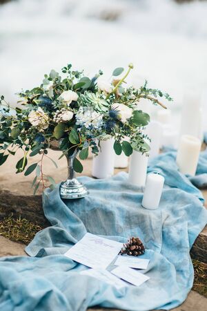 wedding decor with a bouquet and candles on the stones of the Carpathian waterfallの写真素材
