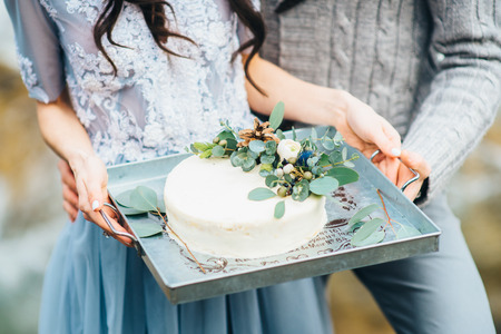wedding cake decorated with fresh flowers on the tray