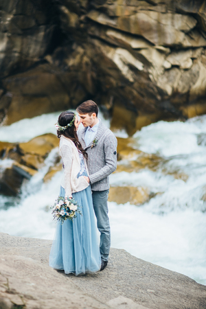 the bride turned to the groom on the background of a mountain riverの写真素材