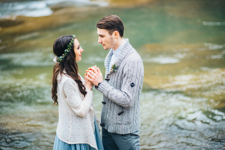 the bride turned to the groom on the background of a mountain riverの写真素材