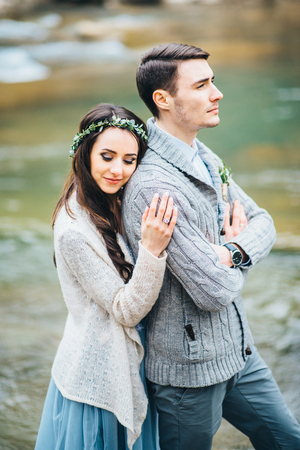 the bride turned to the groom on the background of a mountain riverの写真素材