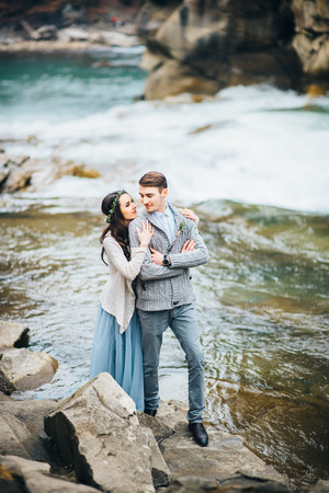 the bride turned to the groom on the background of a mountain riverの写真素材
