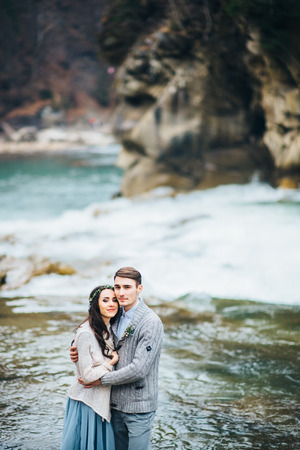 the bride turned to the groom on the background of a mountain riverの写真素材