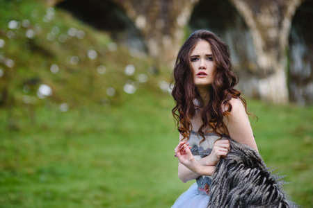 the bride walks under a bridge in a fur Cape in the Carpathiansの写真素材
