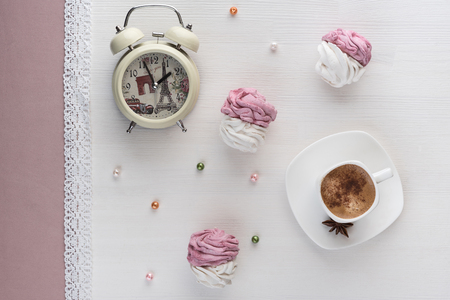 handmade marshmallows near a Cup of coffee and watch the alarm on the laceの写真素材