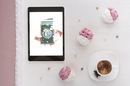 handmade marshmallows next Cup of coffee and a tablet with a picture of the cameraの写真素材