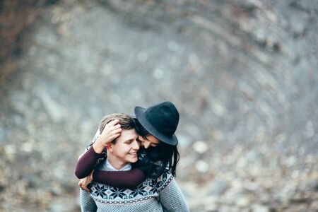 guy and girl in warm sweaters walking along a mountain river, love storyの写真素材