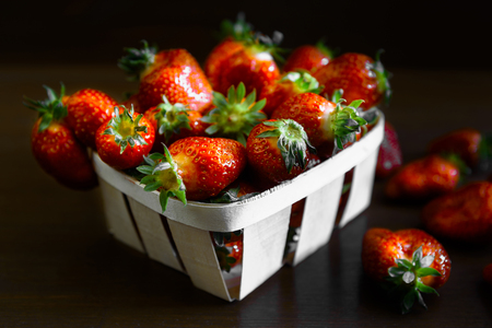 ripe juicy strawberries on a wooden table in a basketの写真素材