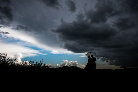 couple under an umbrella in rainy stormy weatherの写真素材