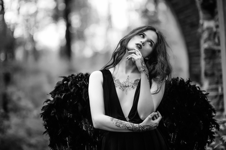 Fallen angel with black wings in the old forestの写真素材