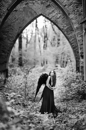 Fallen angel with black wings in the old forestの写真素材