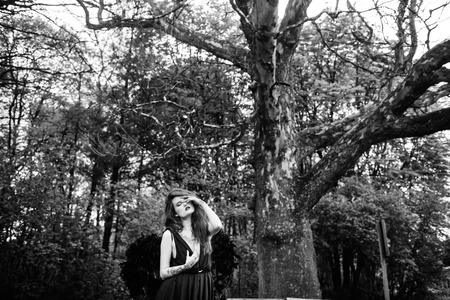 Fallen angel with black wings in the old forestの写真素材