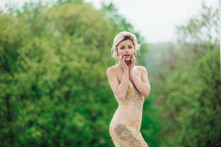 model girl dress gold angel posing in the woods near the old columnsの写真素材