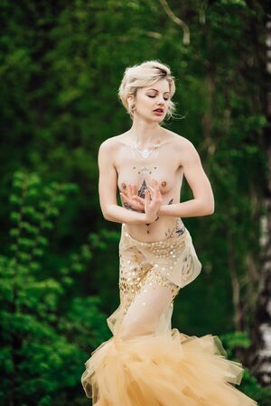 model girl dress gold angel posing in the woods near the old columnsの写真素材