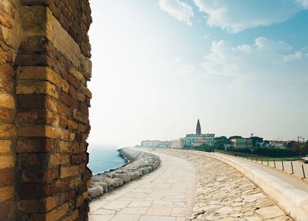 Belltower Duomo Santo Stefano on the seacoast coast in Caorle Italyの写真素材