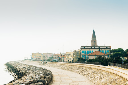 Belltower Duomo Santo Stefano on the seacoast coast in Caorle Italyの写真素材