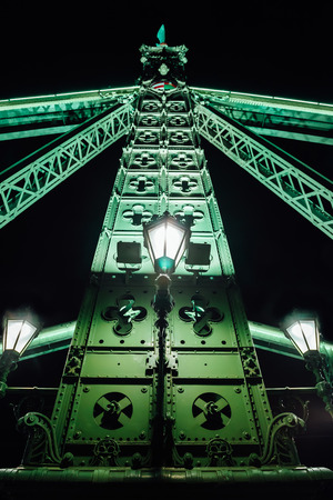Old Iron Bridge at night in the light of streetlights across the Danube River in Budapest Hungaryの写真素材