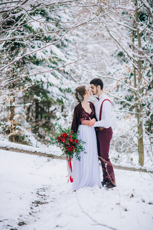groom in a brown and bride in burgundy in the mountains Carpathiansの写真素材