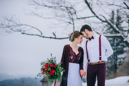 groom in a brown and bride in burgundy in the mountains Carpathiansの写真素材