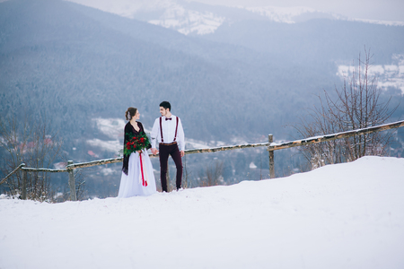 groom in a brown and bride in burgundy in the mountains Carpathiansの写真素材