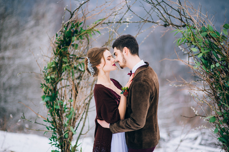 groom in a brown and bride in burgundy in the mountains Carpathiansの写真素材