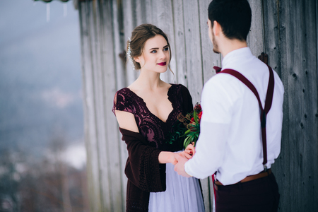 groom in a brown and bride in burgundy in the mountains Carpathiansの写真素材