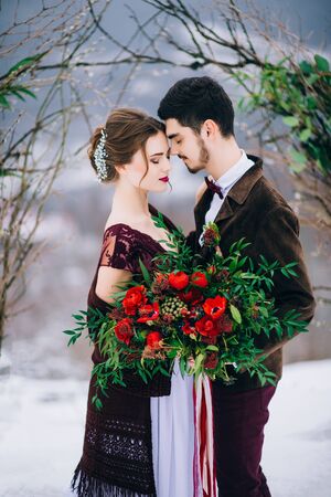 groom in a brown and bride in burgundy in the mountains Carpathiansの写真素材
