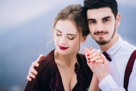 groom in a brown and bride in burgundy in the mountains Carpathiansの写真素材
