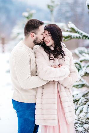 a bride in a fur coat with a fiance among the Carpathian mountainsの写真素材